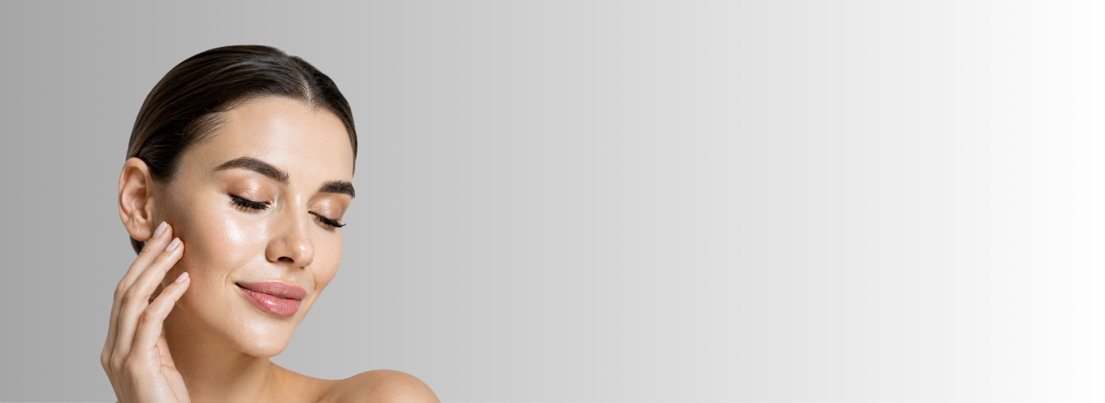 Woman touching her face against a plain background