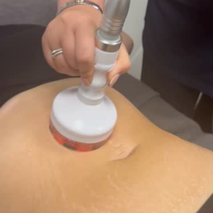 Person using a handheld device on their leg, possibly for medical or cosmetic treatment.